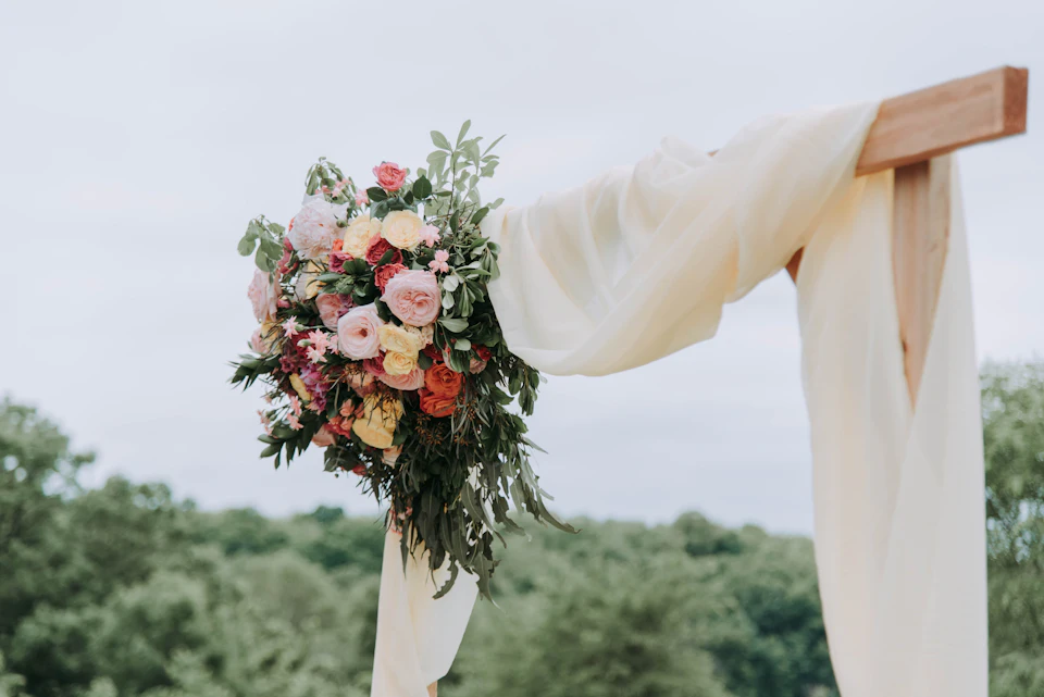 Bouquet of assorted-color flowers hanged on brown plank with white textile