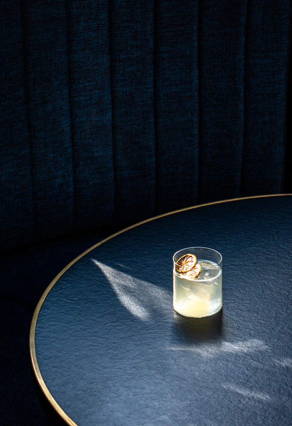 Clear drinking glass with white liquid on blue round table
