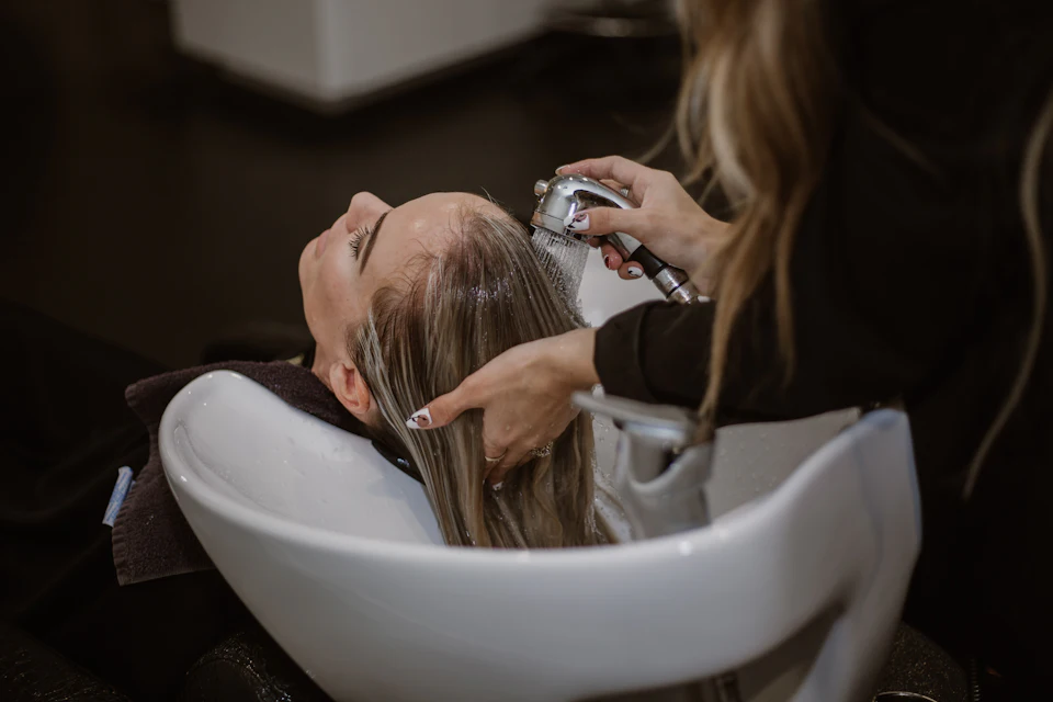 A woman getting her hair cut by a hair stylist