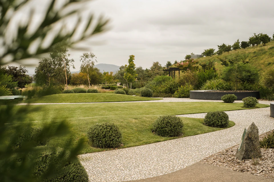 A large green lawn with bushes and trees