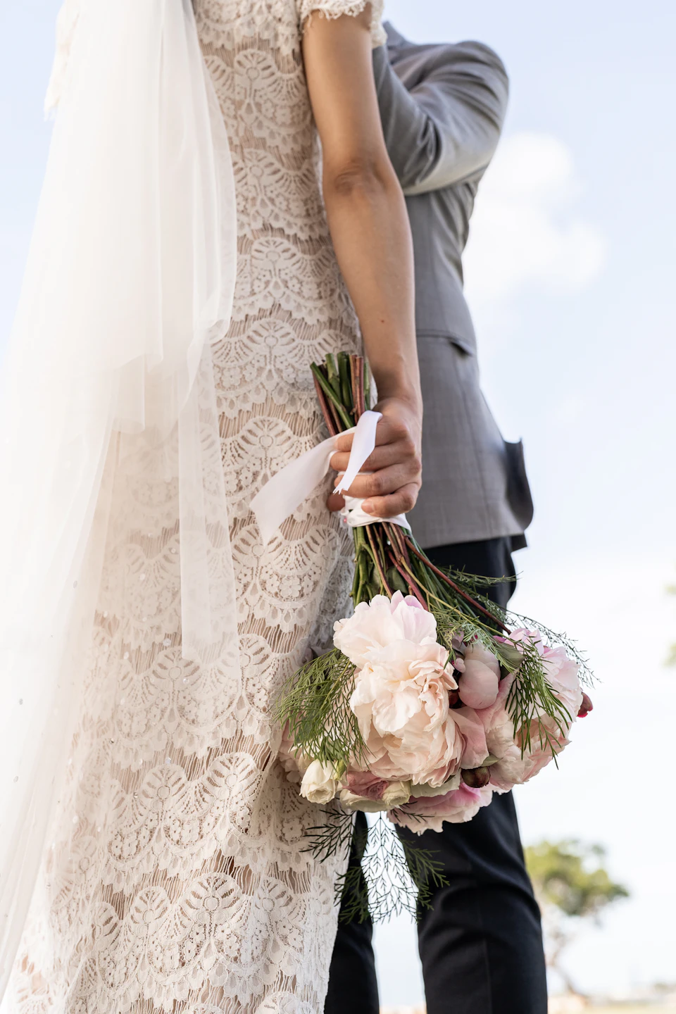 A bride and groom holding a bouquet of flowers