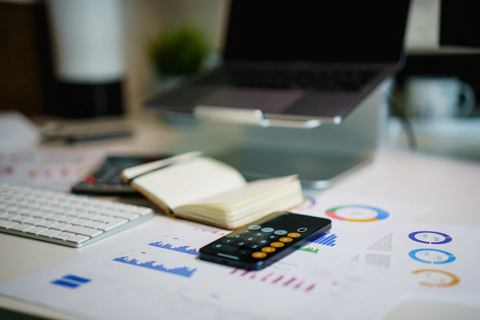 Office desk with smartphone and financial charts