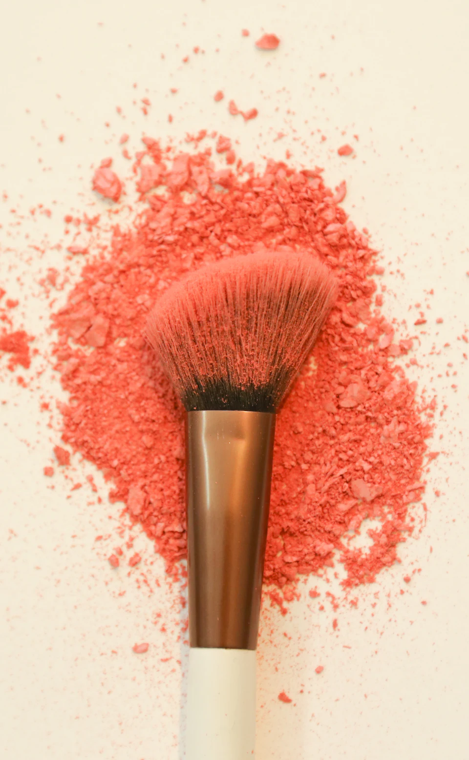 A makeup brush with scattered coral powder