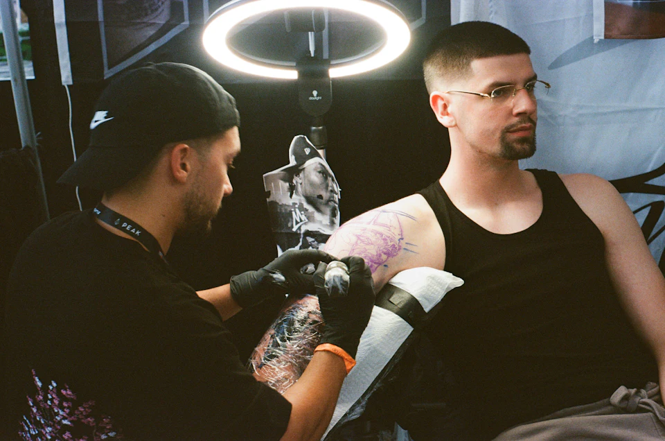 Tattoo artist working on a client's arm