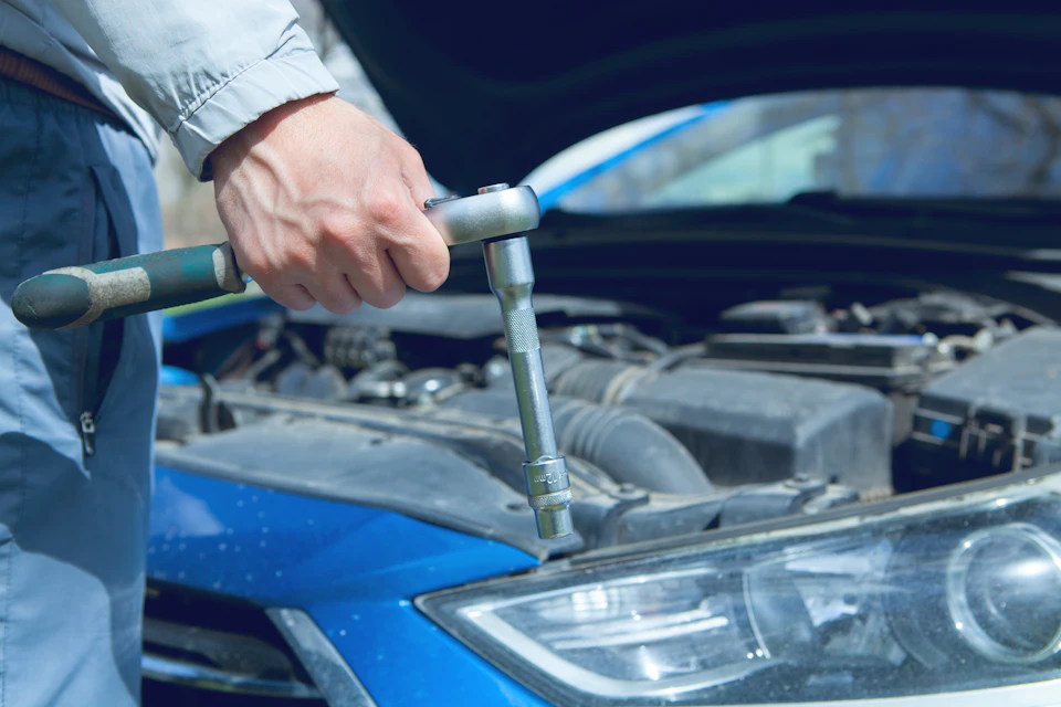 Mechanic using a wrench on a car engine