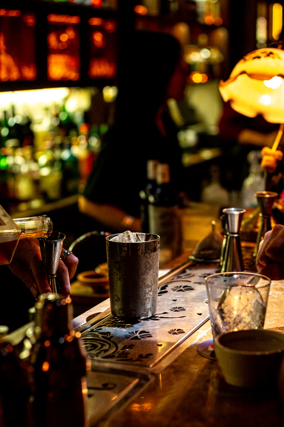 Bartender preparing a cocktail at a dimly lit bar