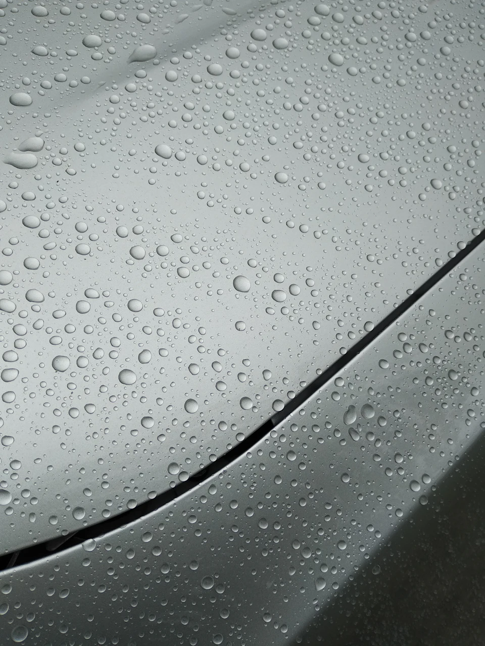 Water droplets on a metallic gray car hood
