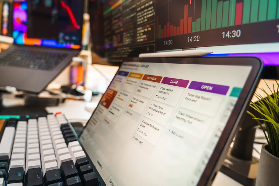 A tablet displaying a project management board with task cards on a desk