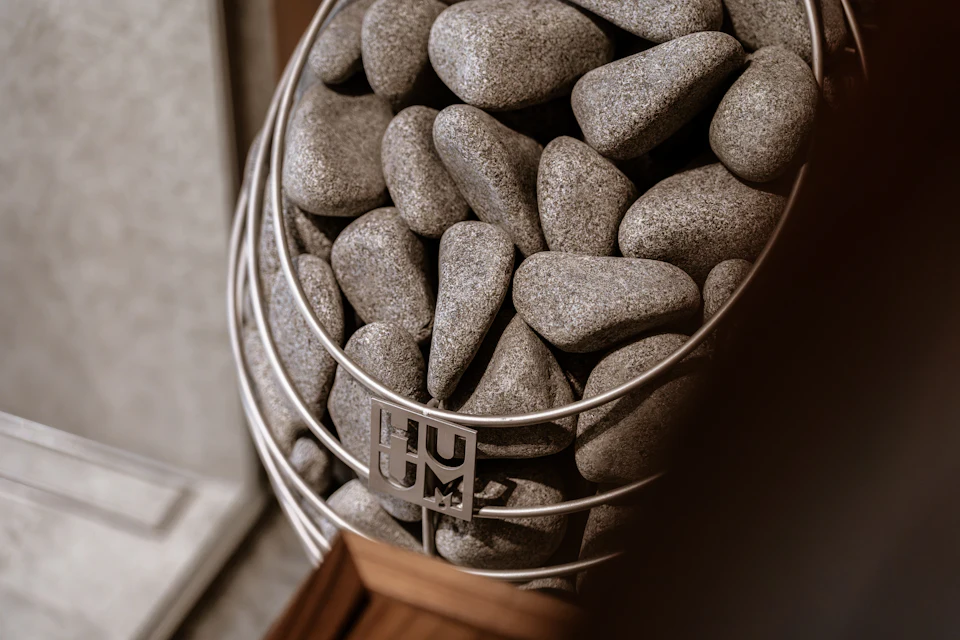 Smooth grey stones stacked inside a metal wire heater basket